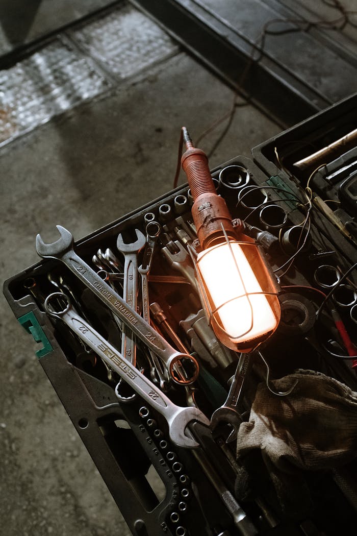 About A detailed view of a workshop setup with various tools and a glowing industrial lamp.